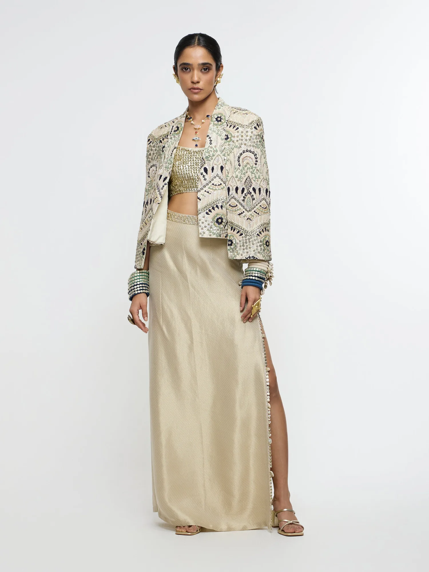 Inayat Embellished Cape Jacket Paired With Metallic Scallop Bustier And Ivory Slit Skirt. by SVA, ivory jacket set